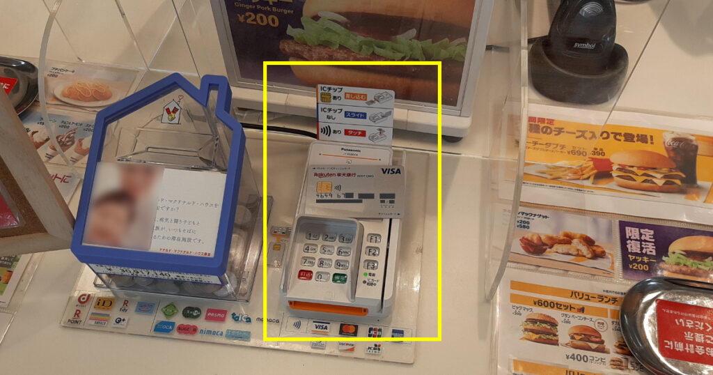 マクドナルドのNFCリーダーに置いた楽天銀行ベーシックデビットカード(Visa)