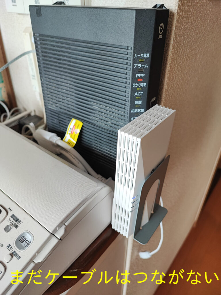 延長コードに取り付けたTP-Link RE600Xと電話機など